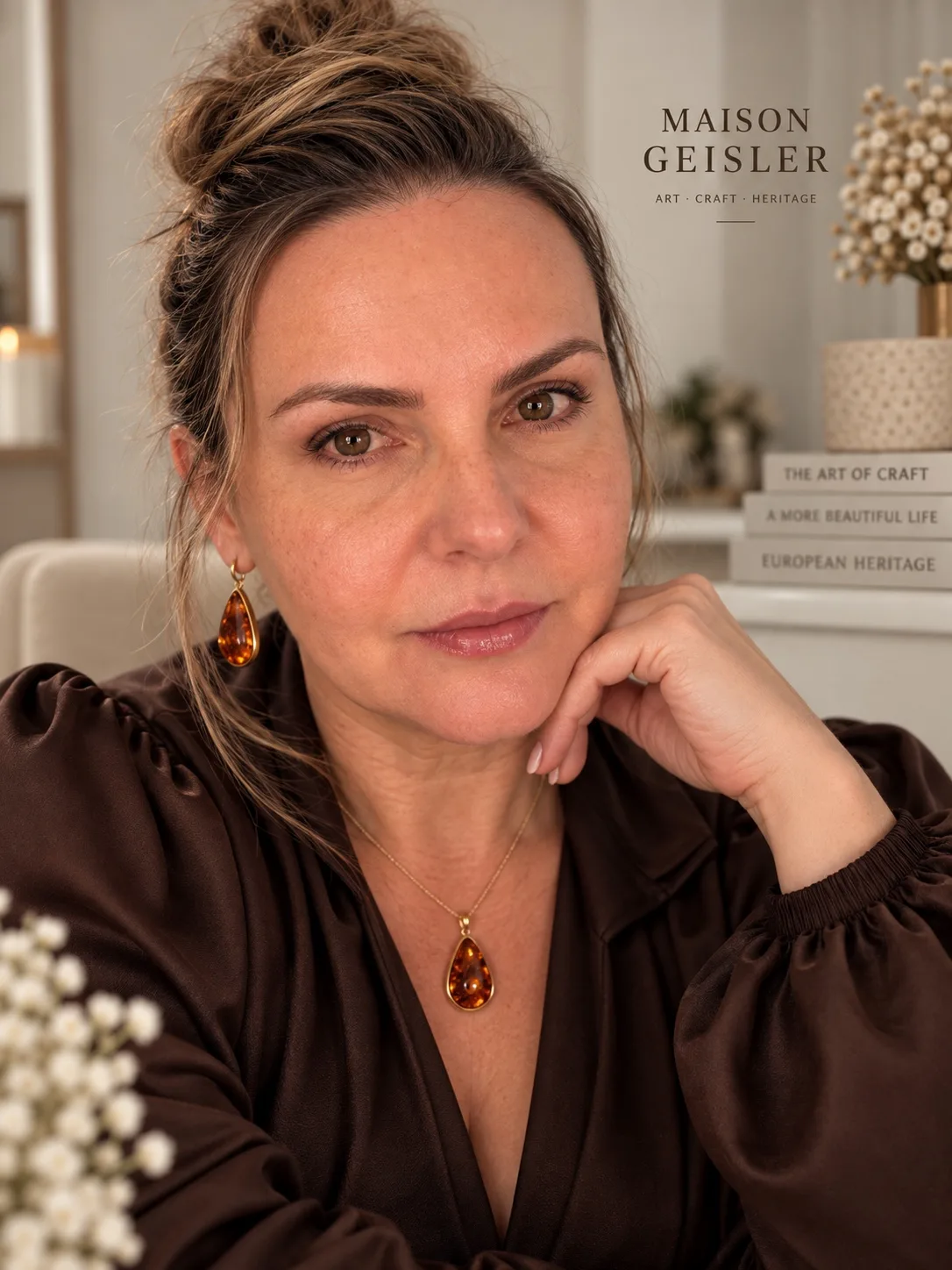 Kasia Geisler, founder of Maison Geisler, wearing amber jewellery and a chocolate-brown blouse.